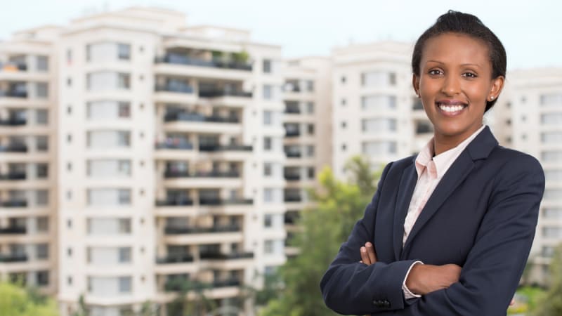 Woman with arms crossed in front of a tall building