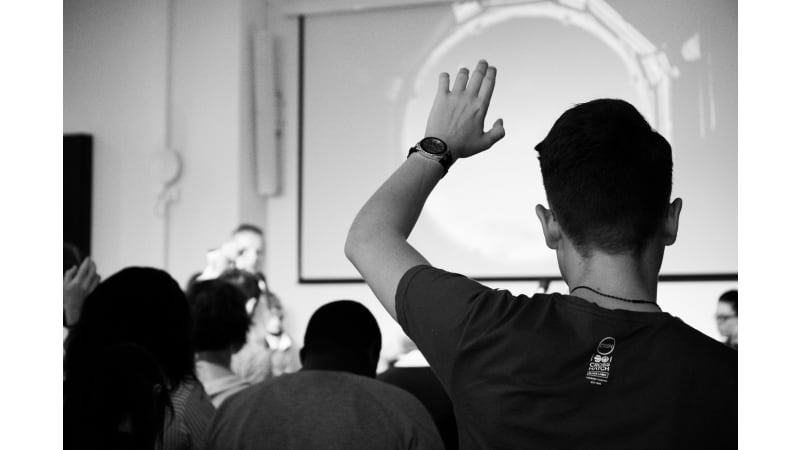 Students raising hands in a classroom